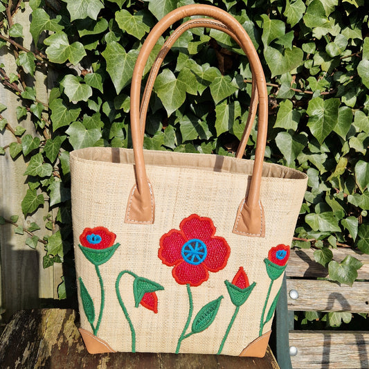 Natural Raffia Basket decorated with red poppies on the front.