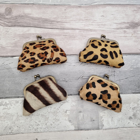 Small coin purses made from textured leather and decorated in animal print.