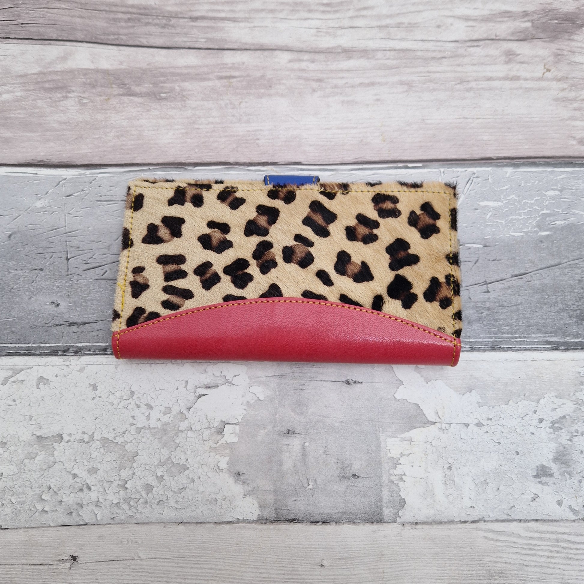 Pink Leather purse with textured leopard print covering.