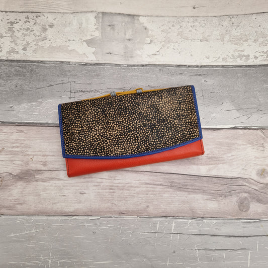 Multi-coloured leather purse made from offcuts. Finished with a textured panel of raw cow hide painted in a dark print with micro dots.