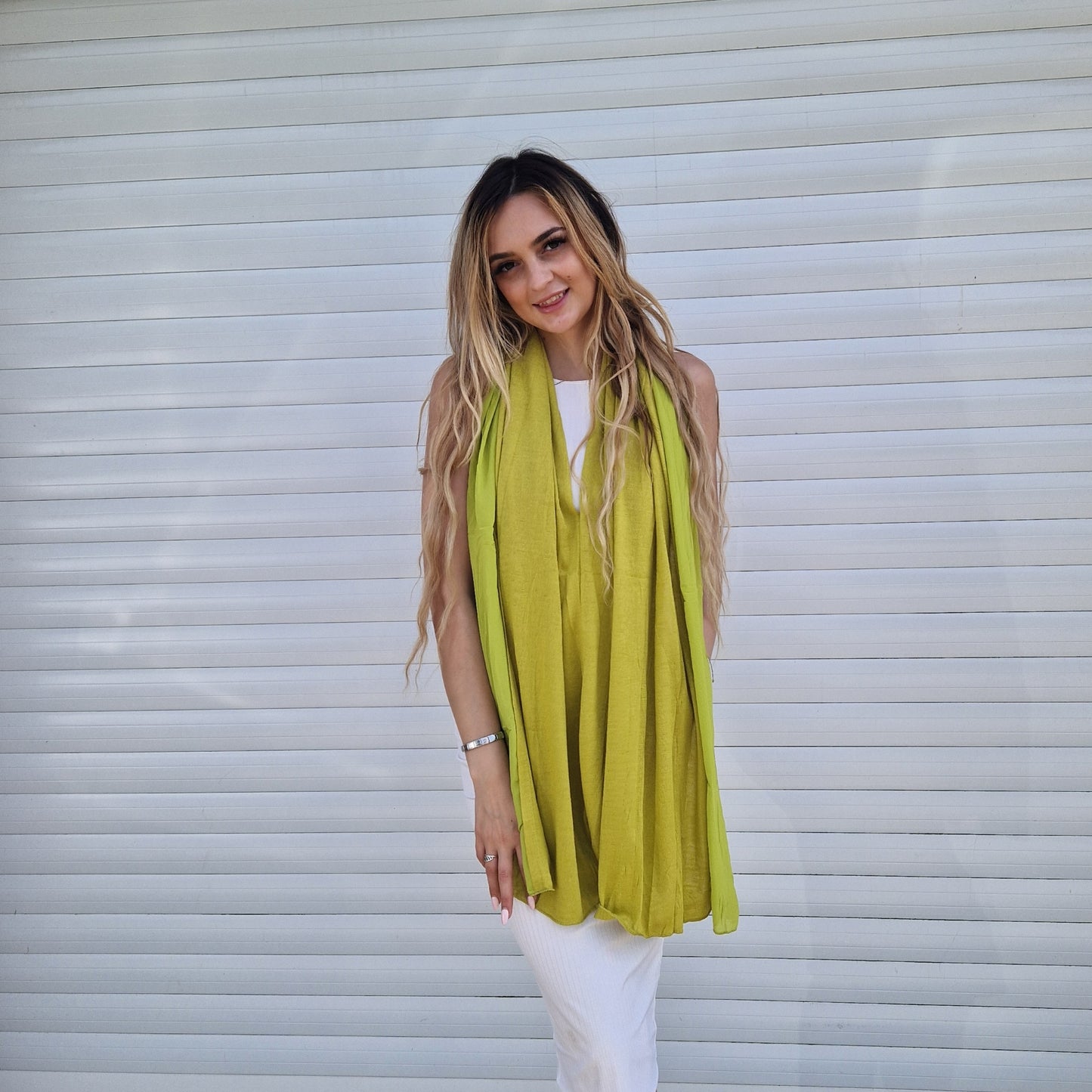 Young woman wearing a lime coloured poncho with a Chiffon trim.