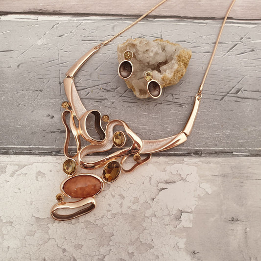Photo of a necklace and earring set in rose gold and amber colourings