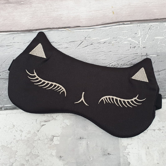 Photo of a Eye Mask in the form of a black cats face with sleeping expression