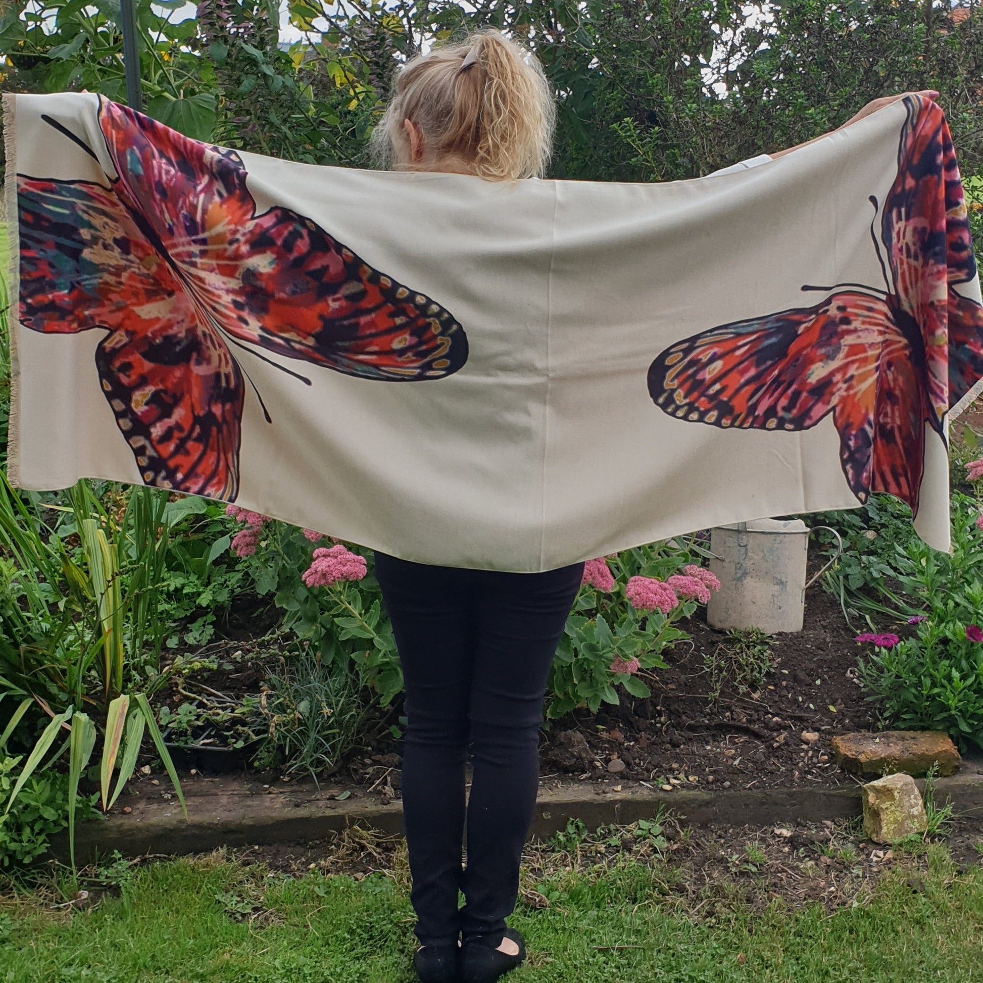 Lady wearing a cream pashmina with a brightly coloured butterfly print