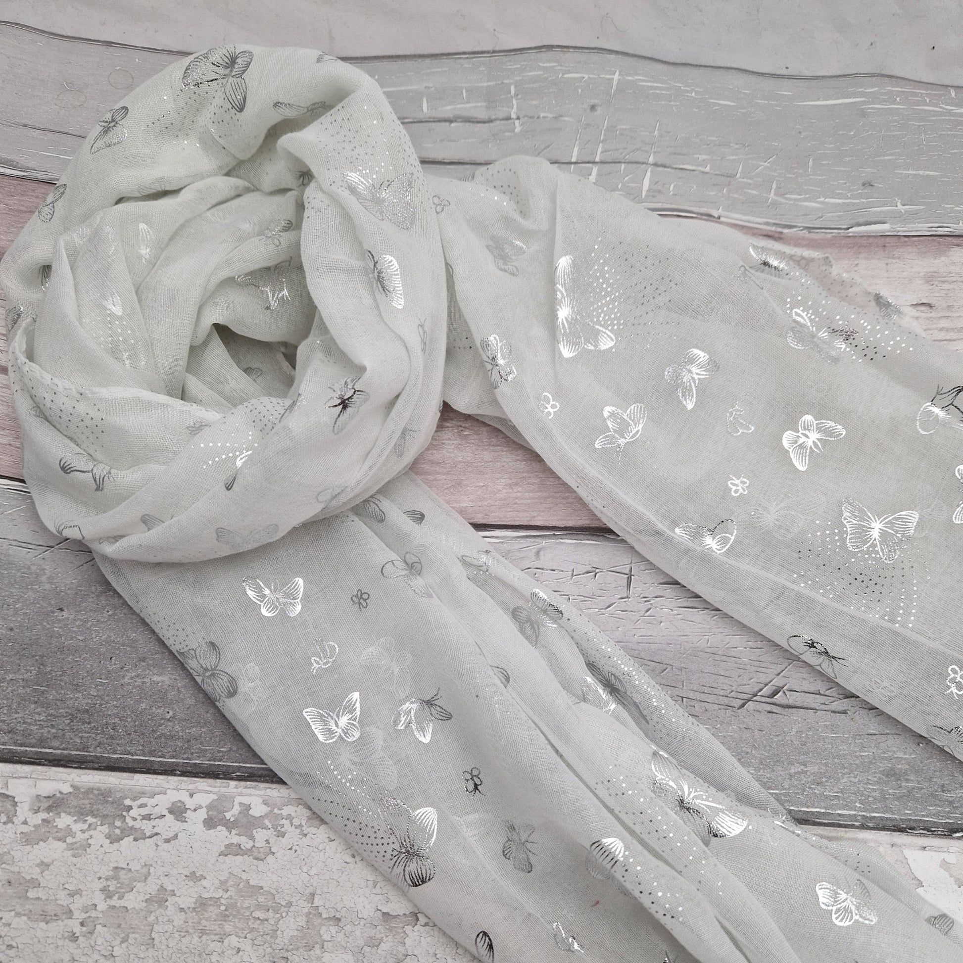 White scarf decorated with metallic silver butterflies.