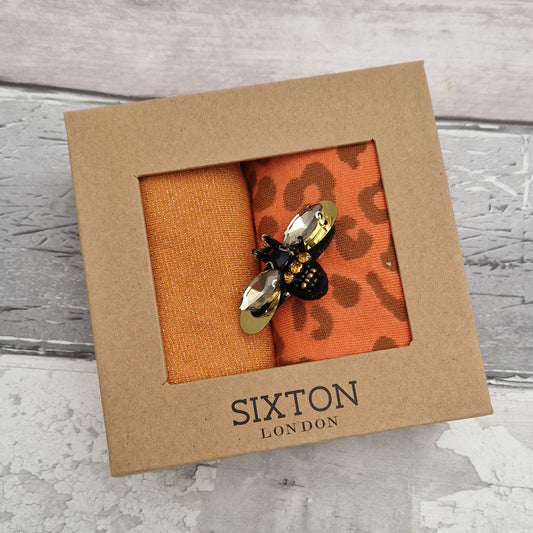 2 Pairs of orange coloured socks presented in a gift box with a sparkling Bee Brooch made of recycled glass.