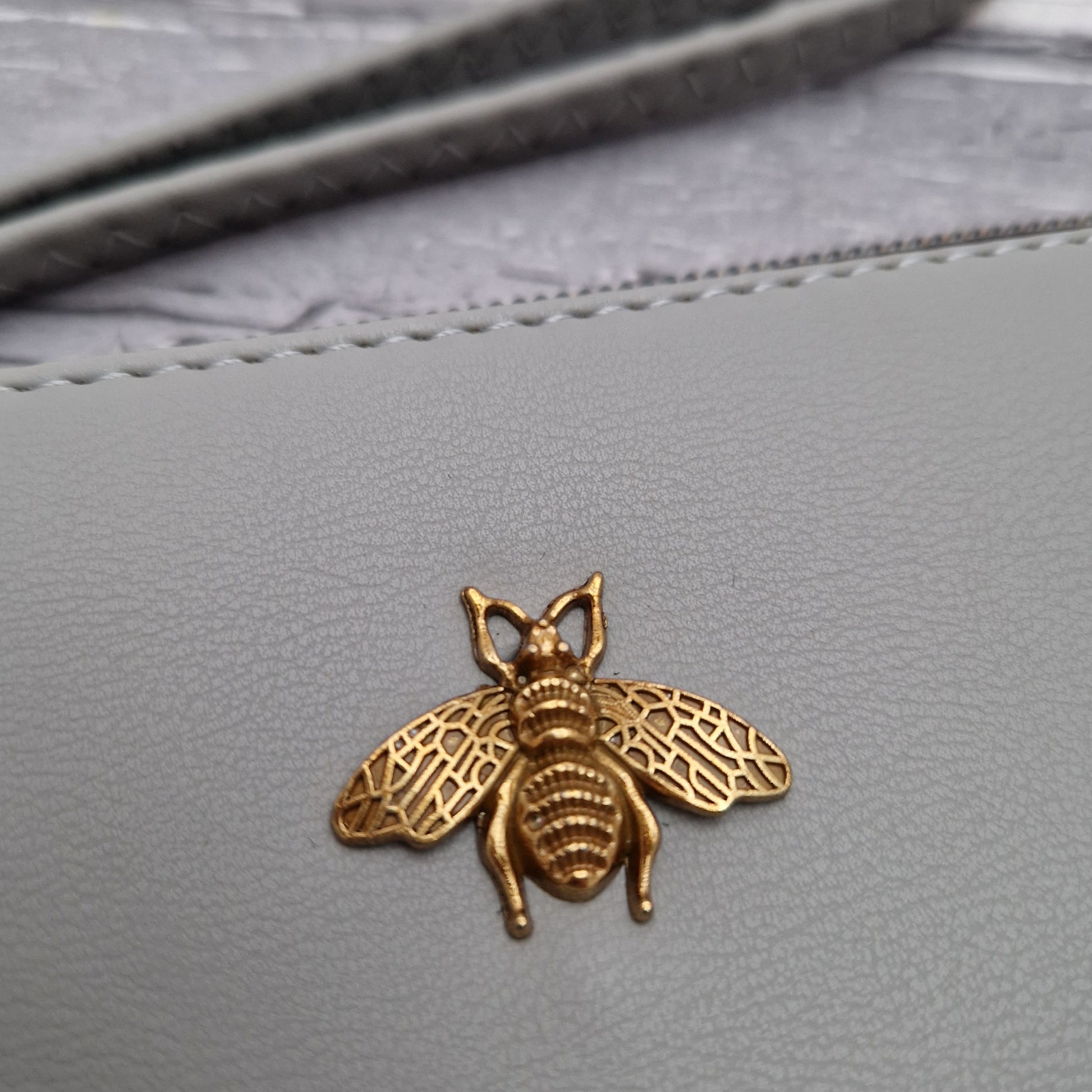 Silver Grey Clutch bag with a Bee emblem