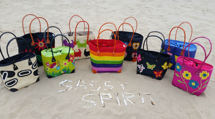 Colourful Sassy Spirit raffia baskets on a beach