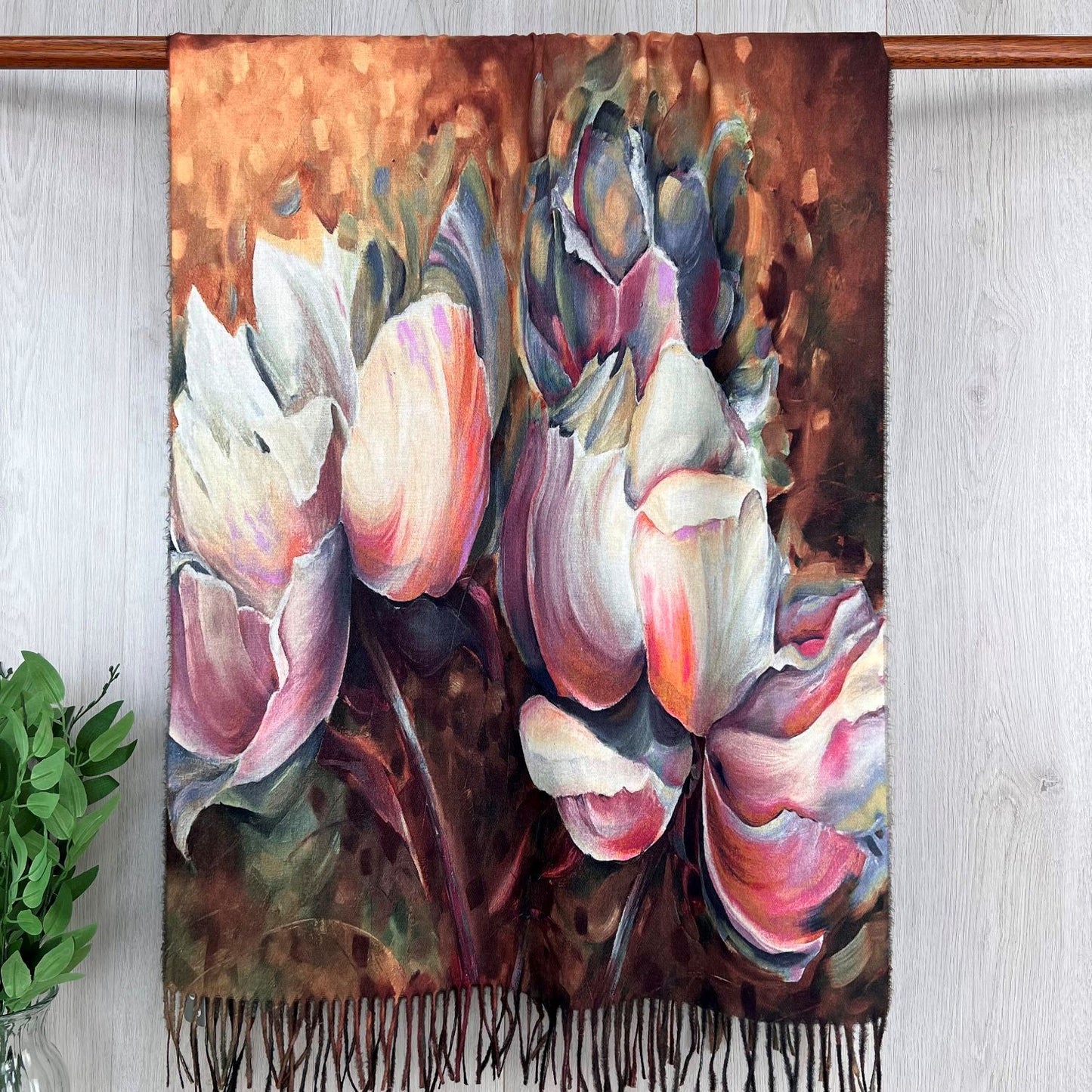 Scarf with floral design hanging on a wooden rod