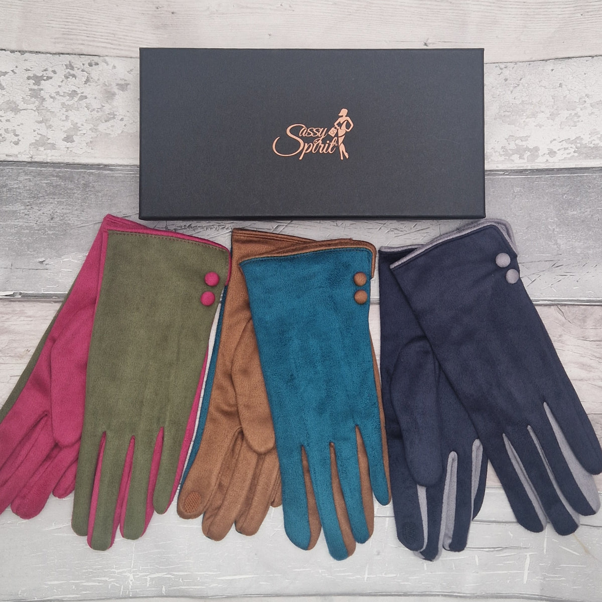 3 Pairs of ladies tow tone coloured gloves in turquoise, olive green and navy beside a Sassy Spirit branded black gift box.