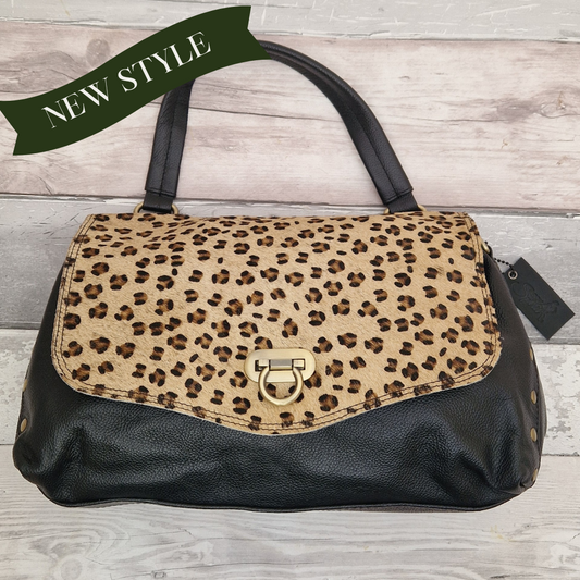 Leopard print handbag with black leather accents on a wooden surface, labeled 'NEW STYLE'.