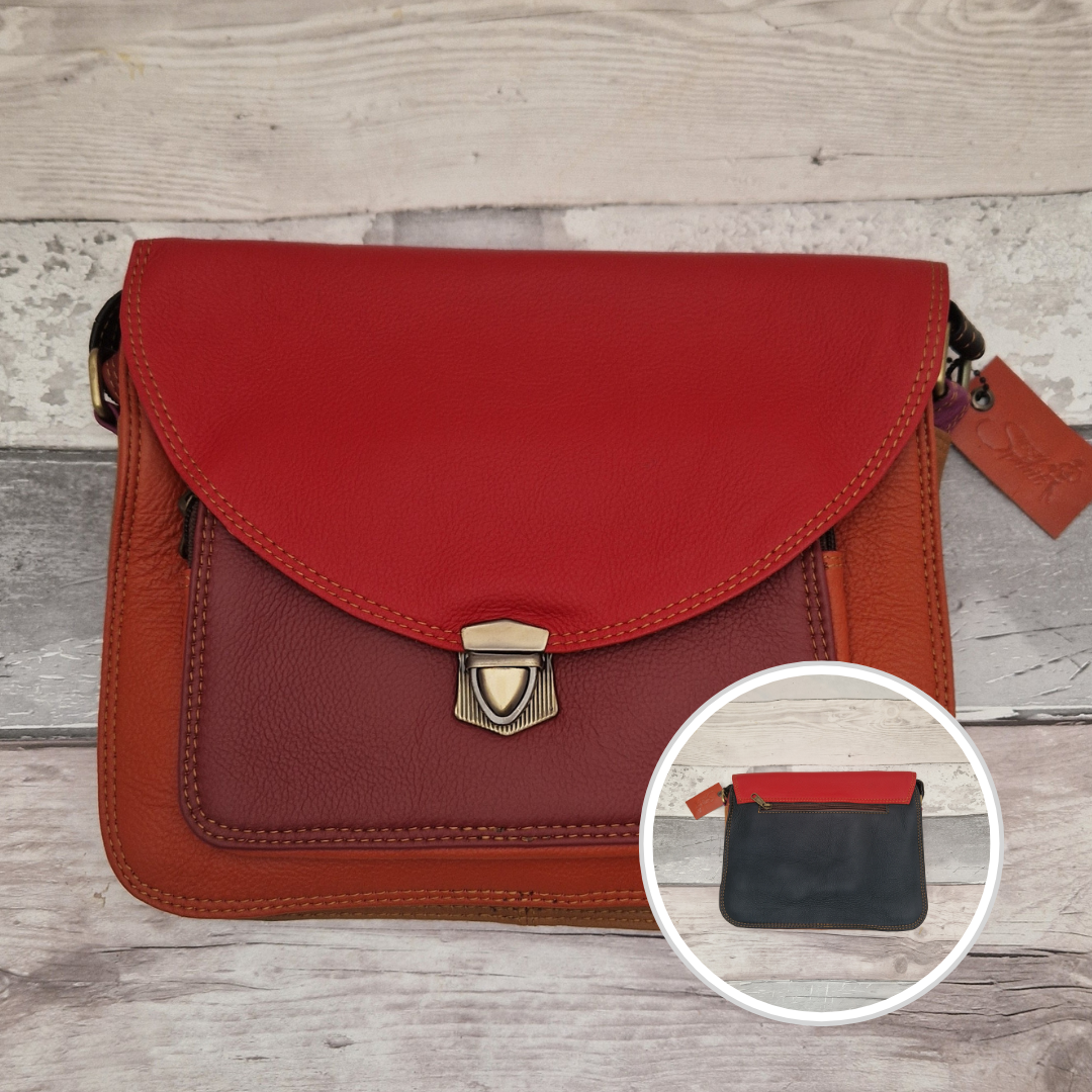 Red and brown leather handbag with a smaller inset showing a black pouch on a wooden surface.