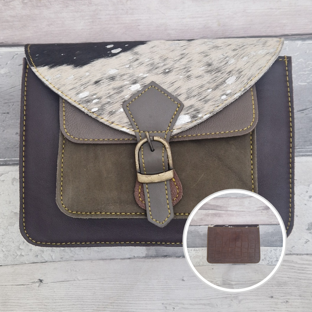 Mini satchel style crossbody bag made with in aubergine with contrasting coloured panels, a buckle closing tab and a textured panel of metallic black and white pony print.