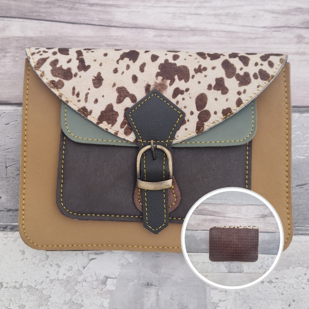 Mini satchel style crossbody bag made with in mustard with contrasting coloured panels, a buckle closing tab and a textured panel of cow print.