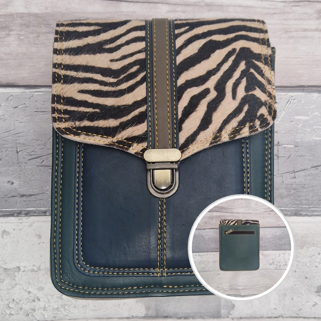 Turquoise leather crossbody bag with a textured panel of zebra print. Accessed via a push clasp.