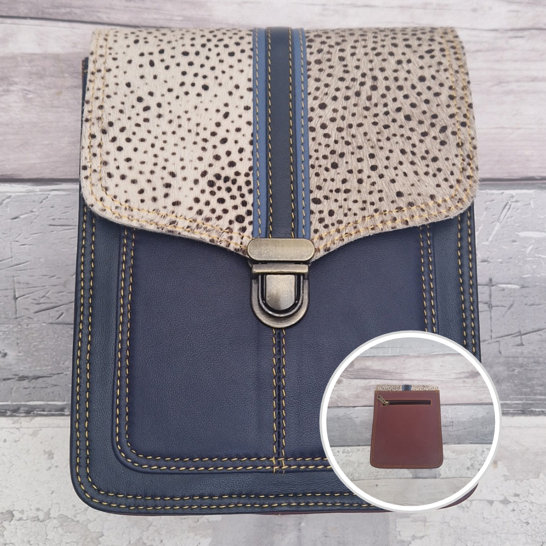 Blue leather crossbody bag with a textured panel of spot print. Accessed via a push clasp.