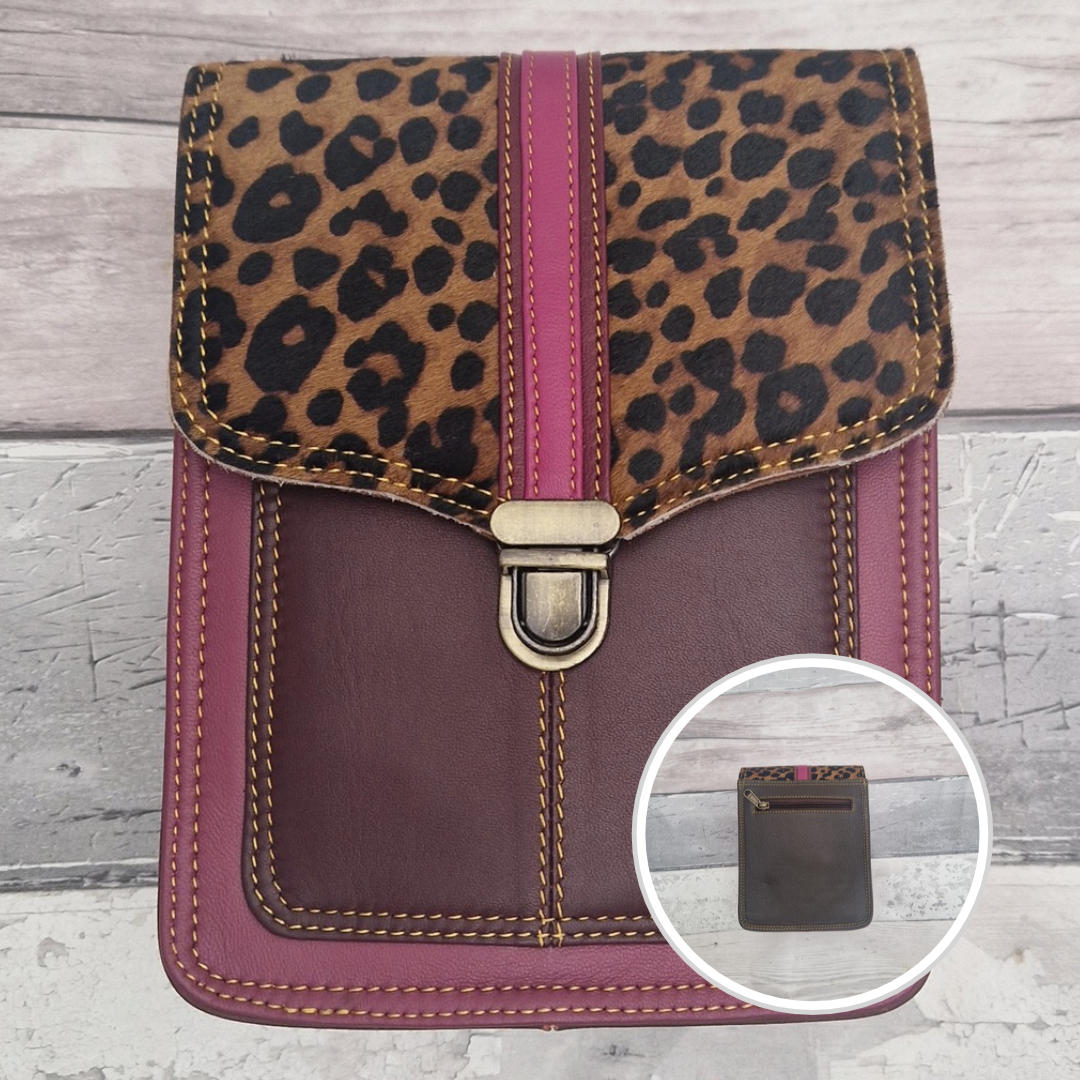 Raspberry leather crossbody bag with a textured panel of cheetah print. Accessed via a push clasp.