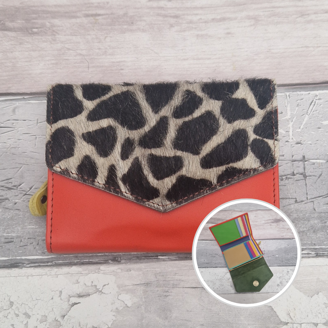 Red leather purse with a textured panel of giraffe print.