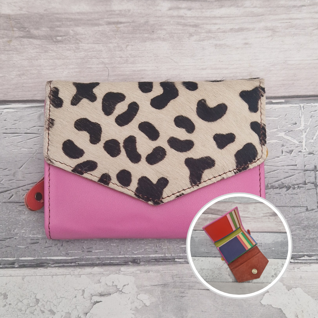 Bubblegum pink leather purse with a textured panel of abstract black and white print.