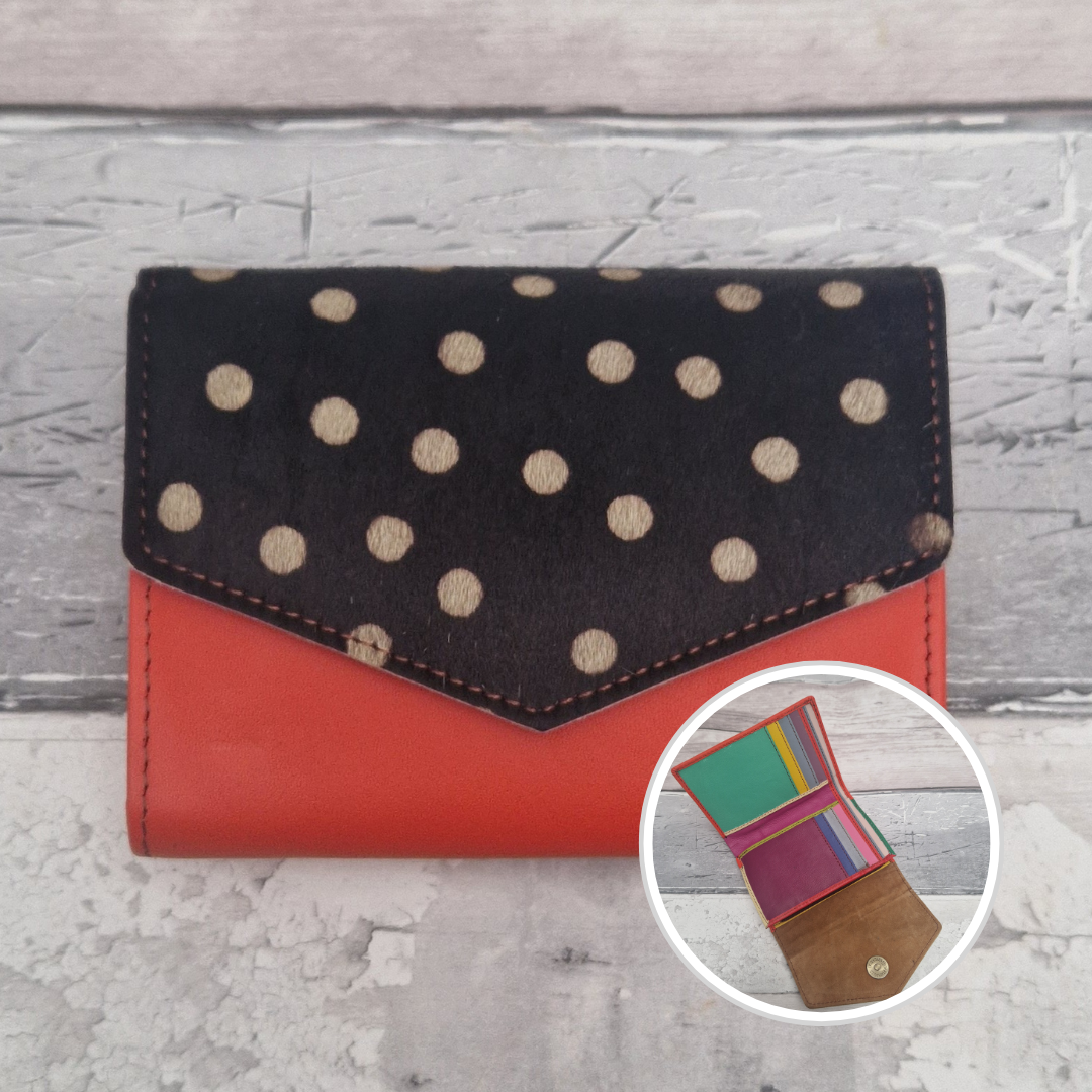 Red leather purse with a textured panel of spotty print.