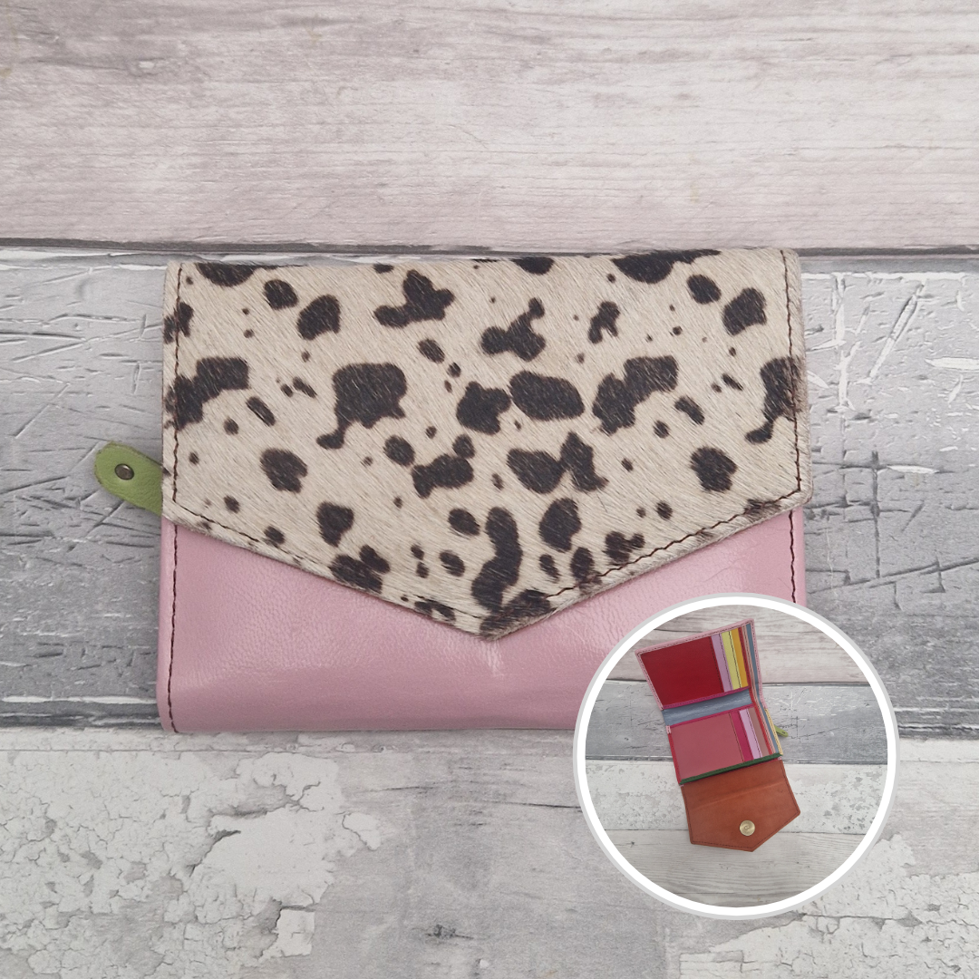 Pale pink leather purse with a textured panel of cow print.