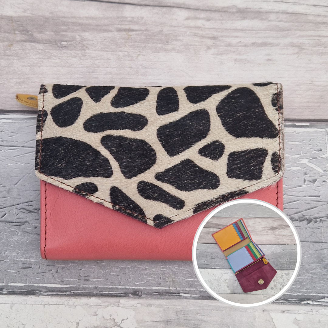 Pink leather purse with a textured panel of giraffe print.
