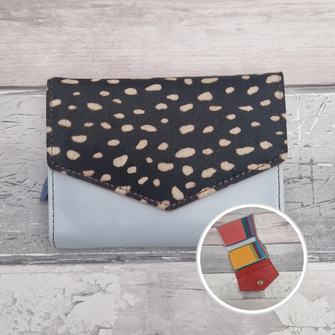 Blue leather purse with a textured panel of abstract spot print.