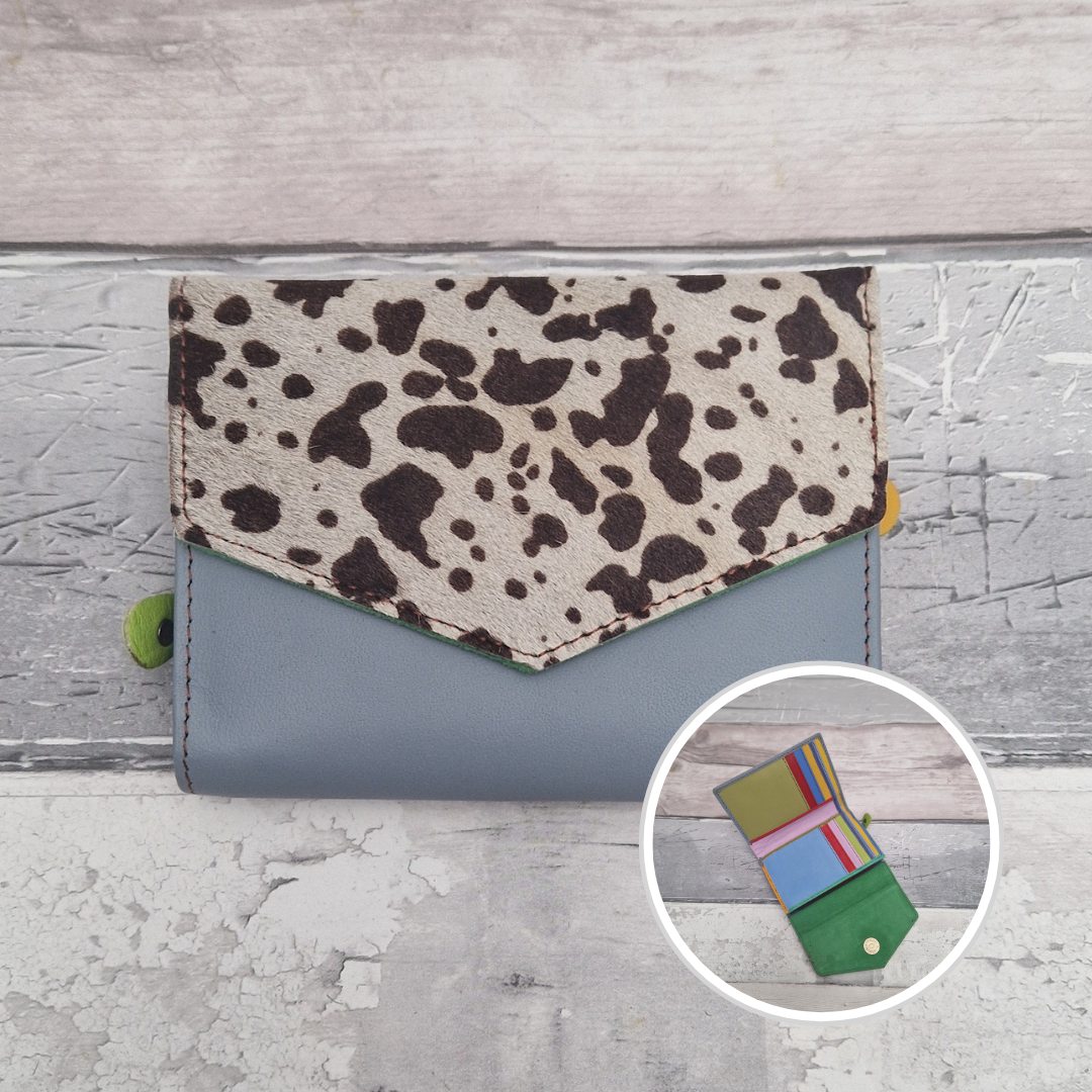 Blue leather purse with a textured panel of cow print.