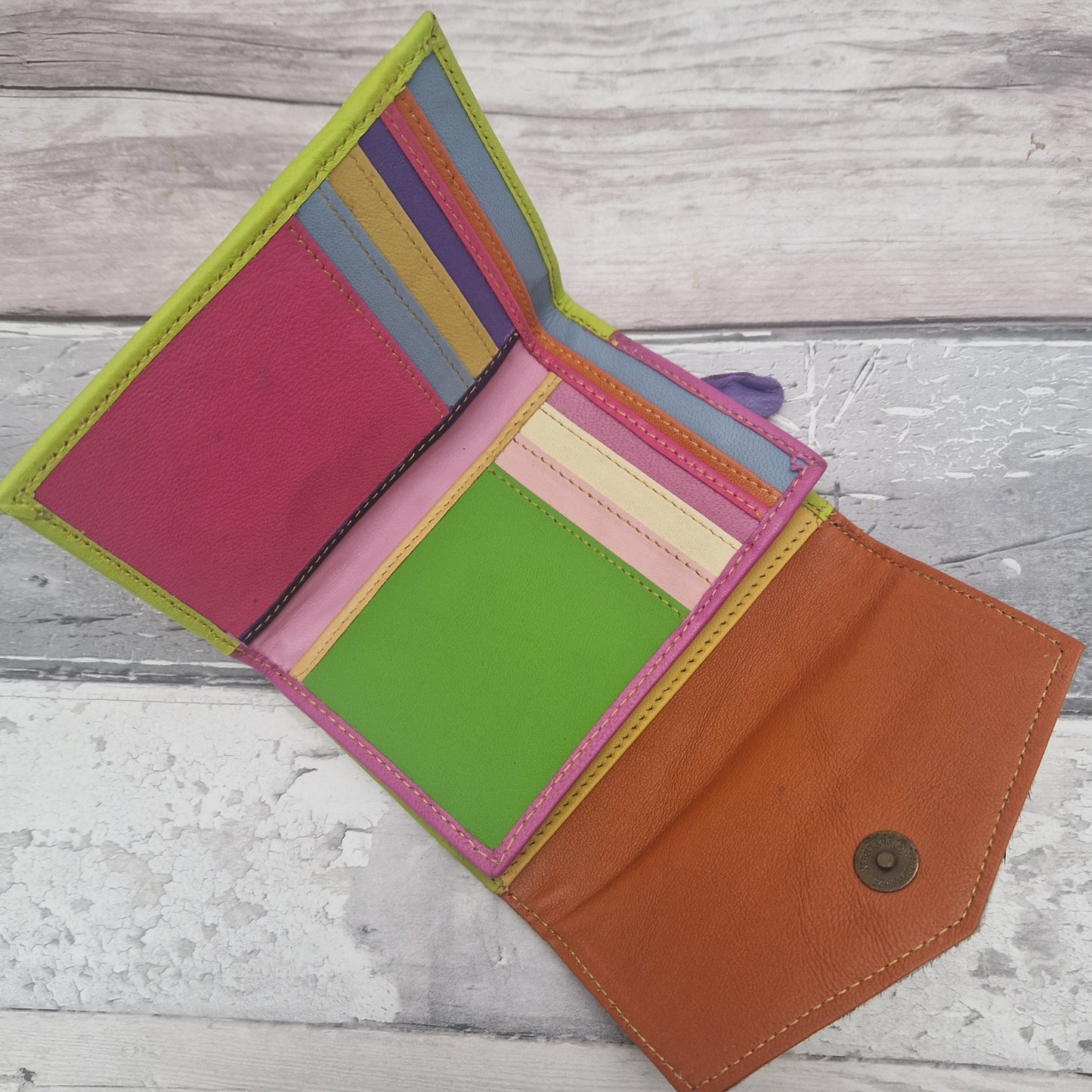 Devi purse opened out on a flat surface showing a multi-coloured interior.