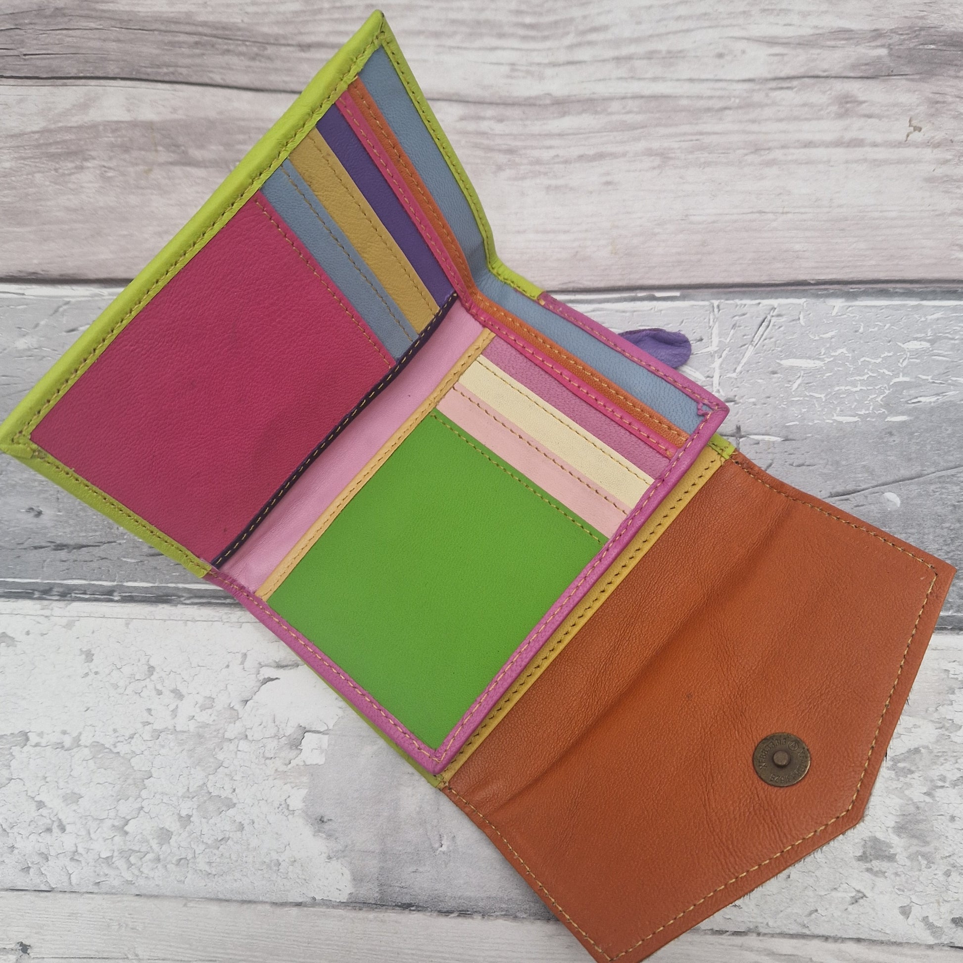 Devi purse opened out on a flat surface showing a multi-coloured interior.