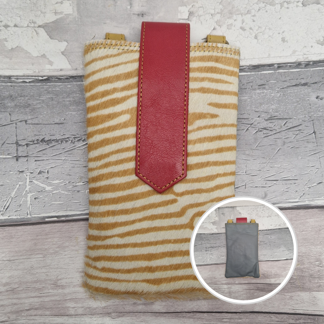 Phone case with zebra pattern and red accent on a wooden surface
