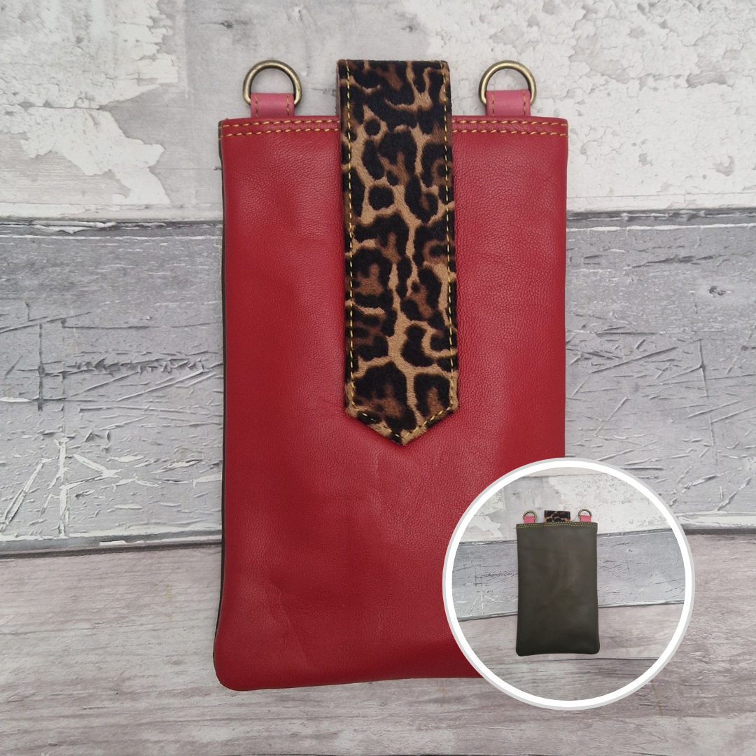 Red leather pouch with leopard print tag on a textured surface