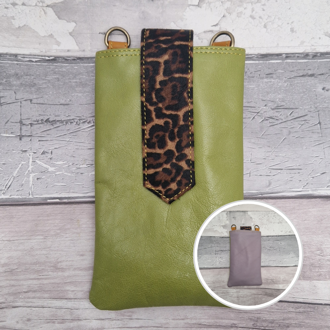 Green phone case with leopard print strap on a textured surface