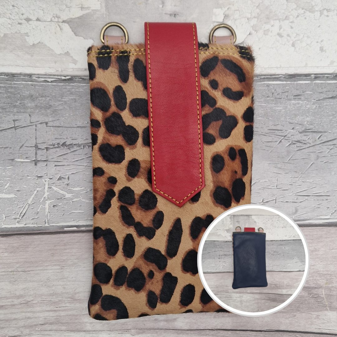 Leopard print phone case with a red strap on a gray wooden surface