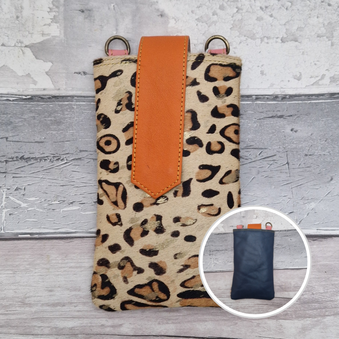 Crossbody body all leather pouch with a leopard print exterior and orange accent.