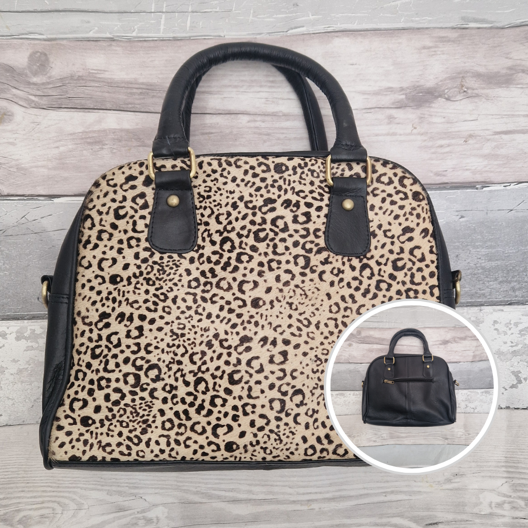 Bowling bag style handbag made from black leather. Textured panel of cow hide has been decorated with a striking chettah print.