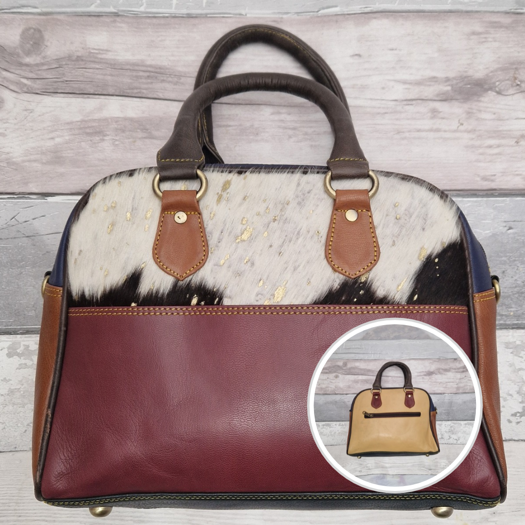 Bowling bag style handbag made from multi-coloured leather pieces. Textured panel of cow hide has been decorated with a striking metallic gold splatter.