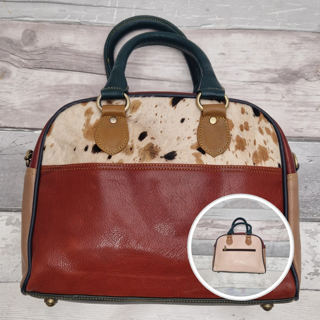Bowling bag style handbag made from multi-coloured leather pieces. Textured panel of cow hide featured.