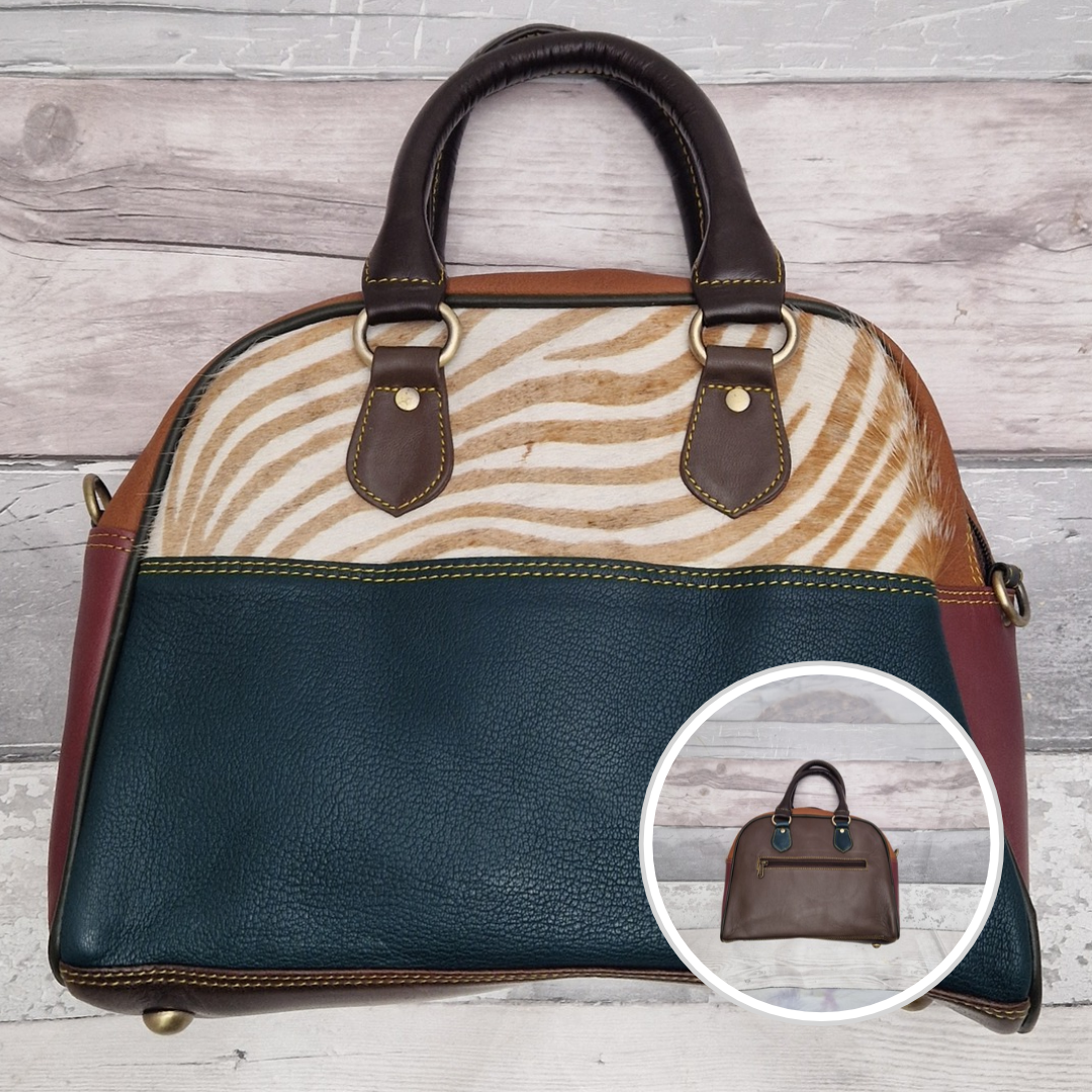 Bowling bag style handbag made from multi-coloured leather pieces. Textured panel of cow hide has been decorated with a striking zebra print.