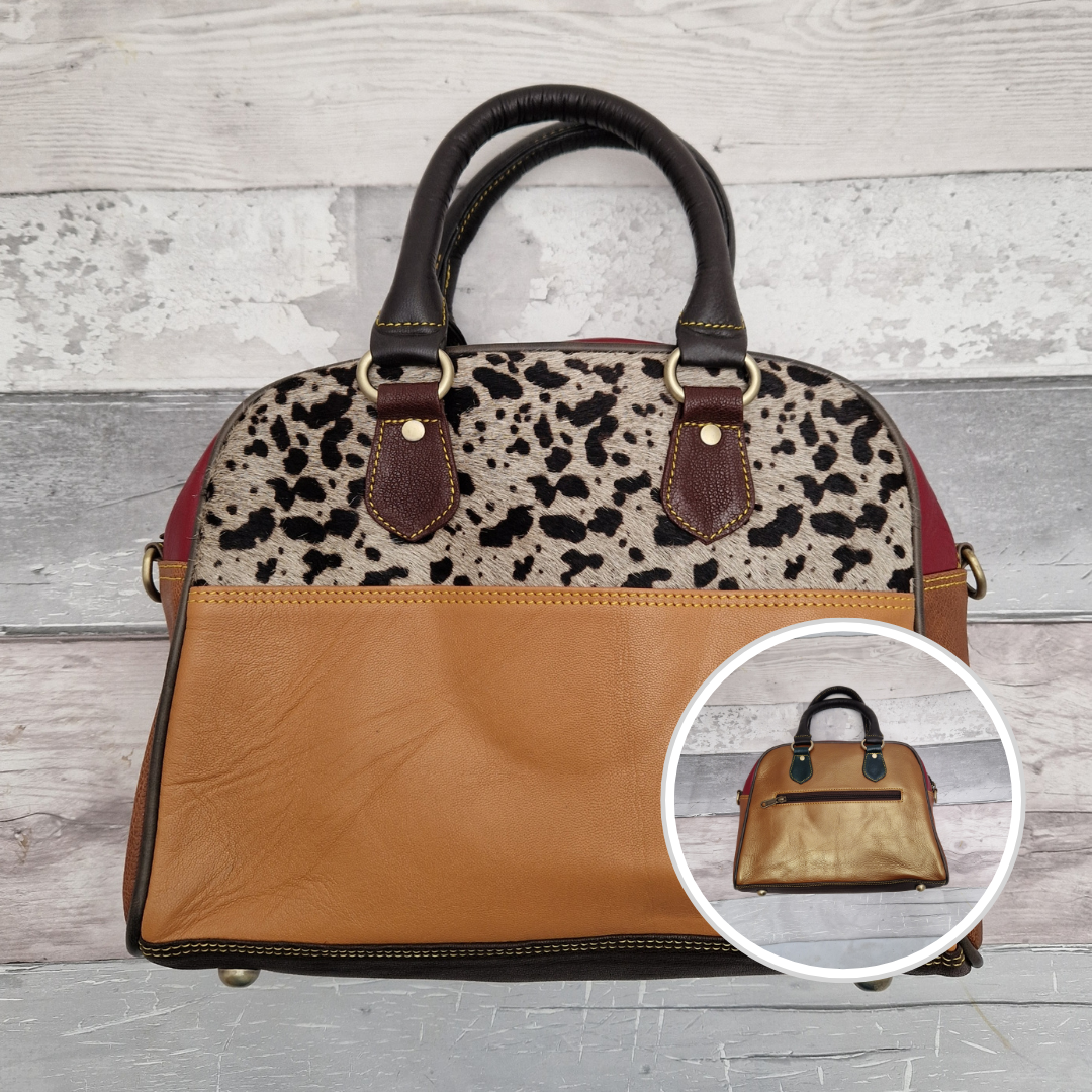 Bowling  bag style handbag made from leather off cuts in a variety of different colours. Textured panel of cow hide has been decorated with a striking cow print.
