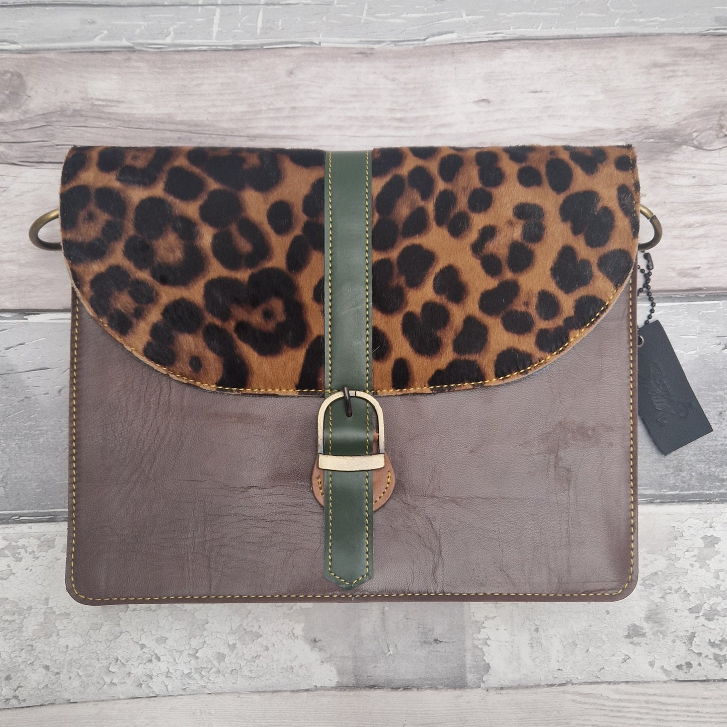 Dark brown Leopard print leather bag with a  on a wooden surface