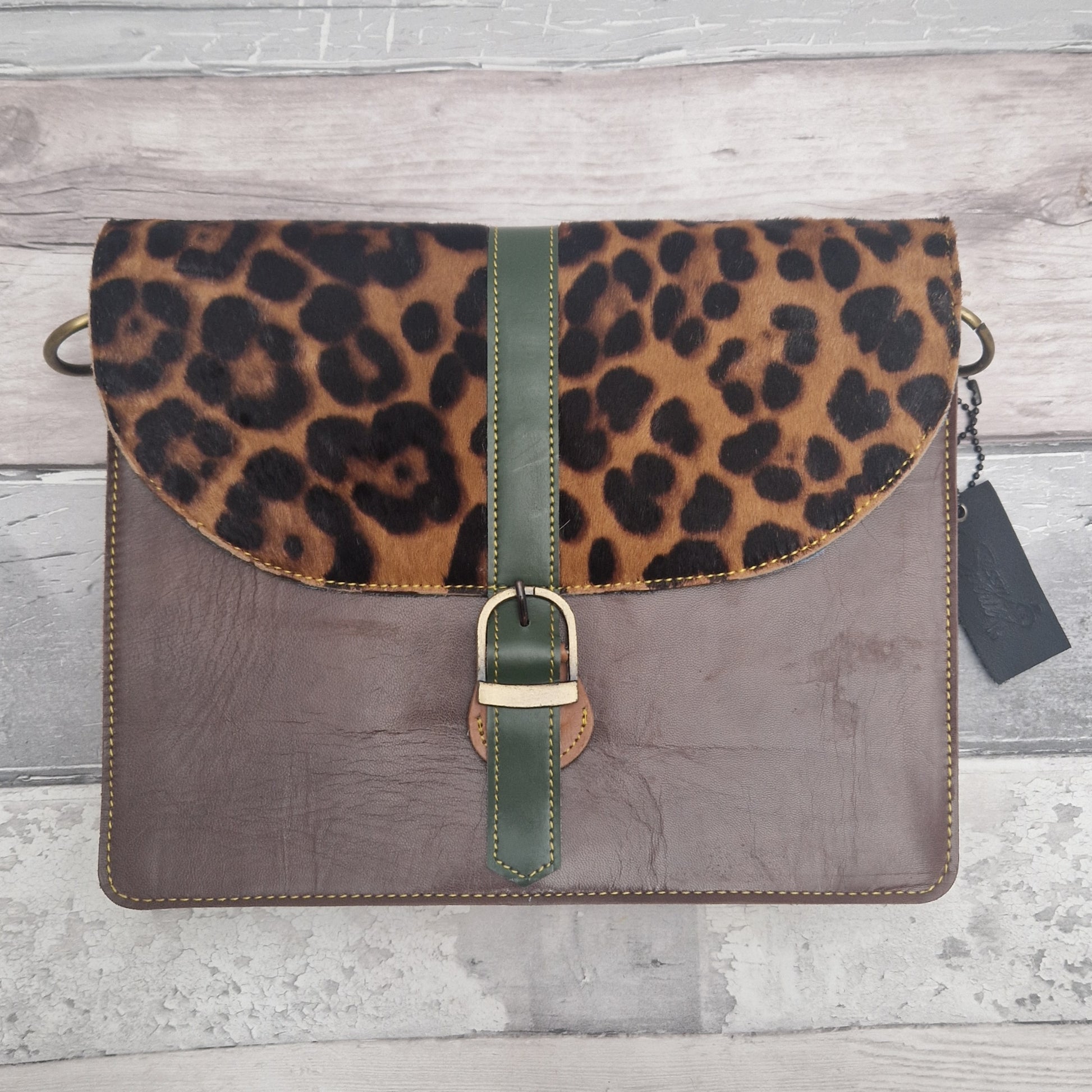Dark brown Leopard print leather bag with a  on a wooden surface