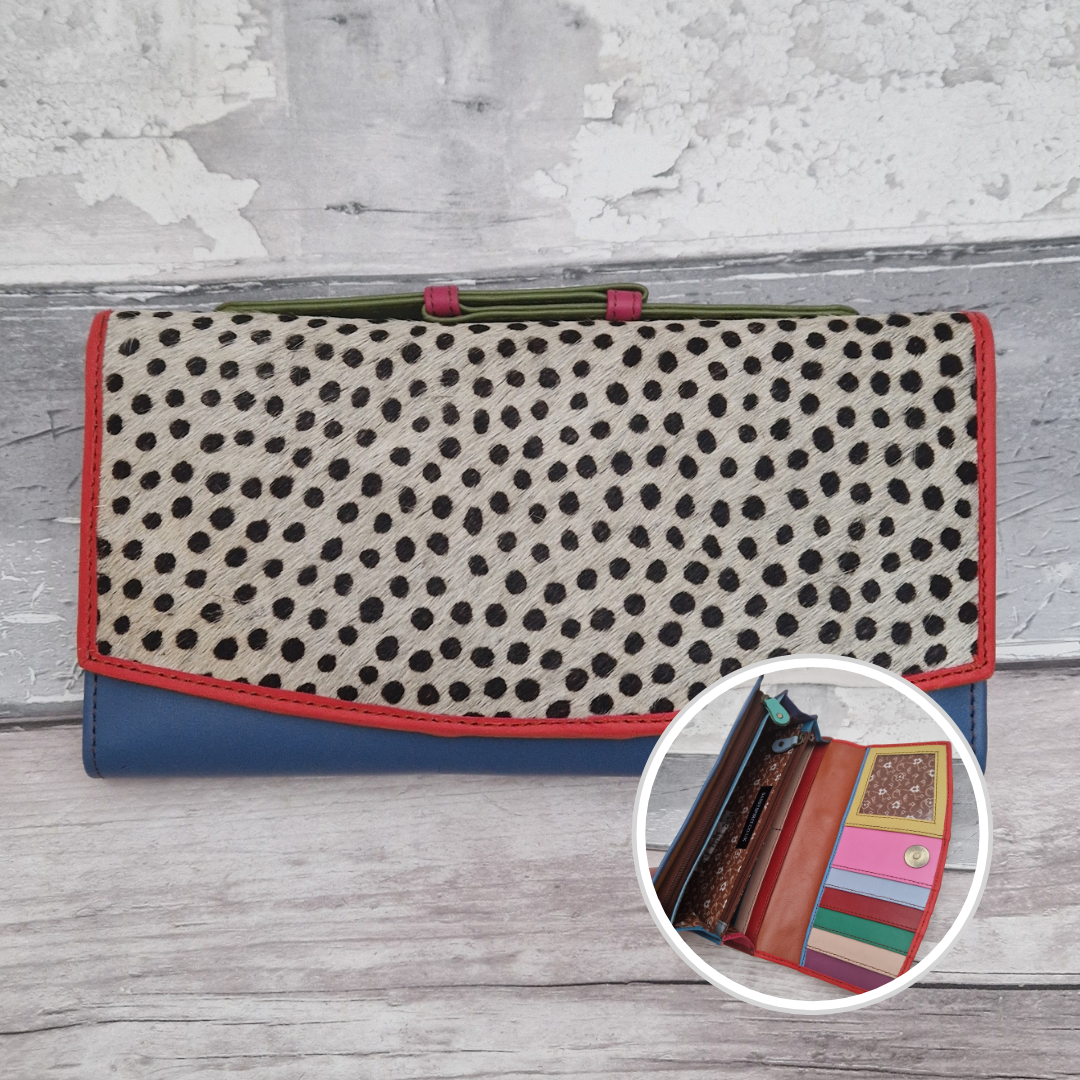 All leather purse with a blue and red coloured exterior and textured panel of cow print.