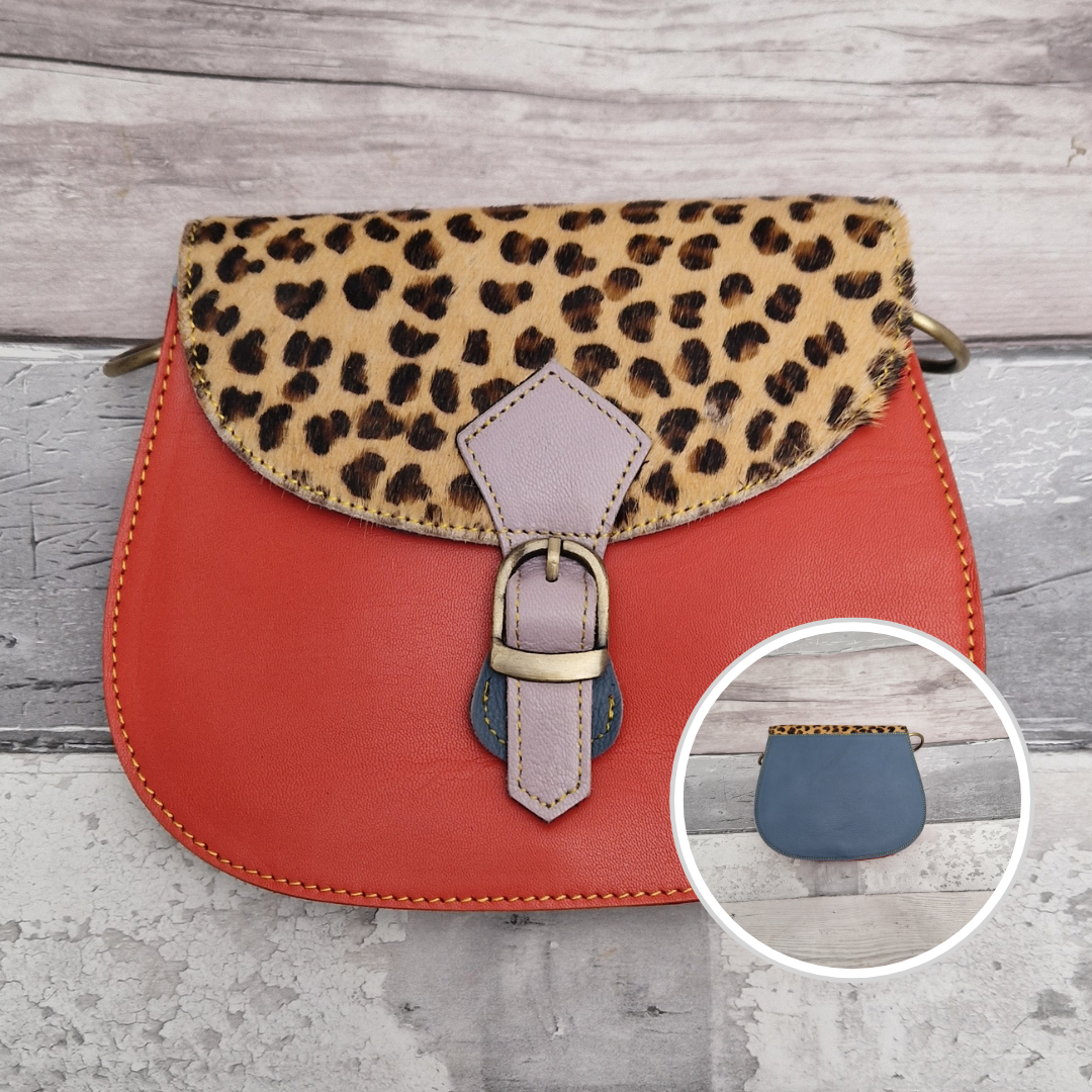 Leather saddlebag shaped bag with a bright orange front and a textured panel of Leopard print.