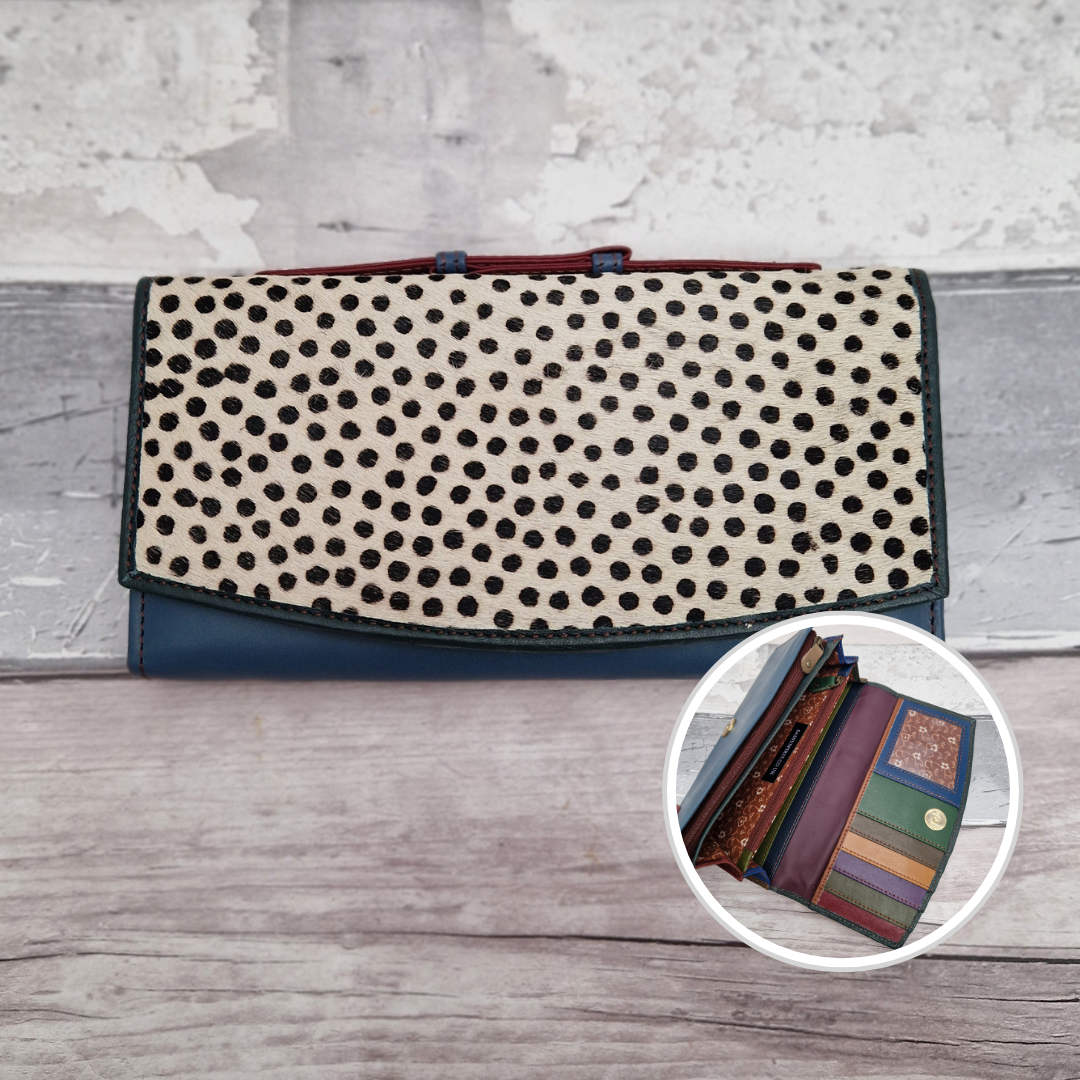 All leather purse with a turquoise and dark green coloured exterior and textured panel of spot print.