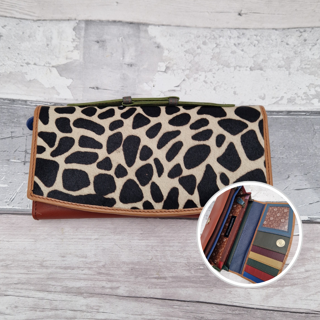 All leather purse with a rusty and blush coloured exterior and textured panel of giraffe print.