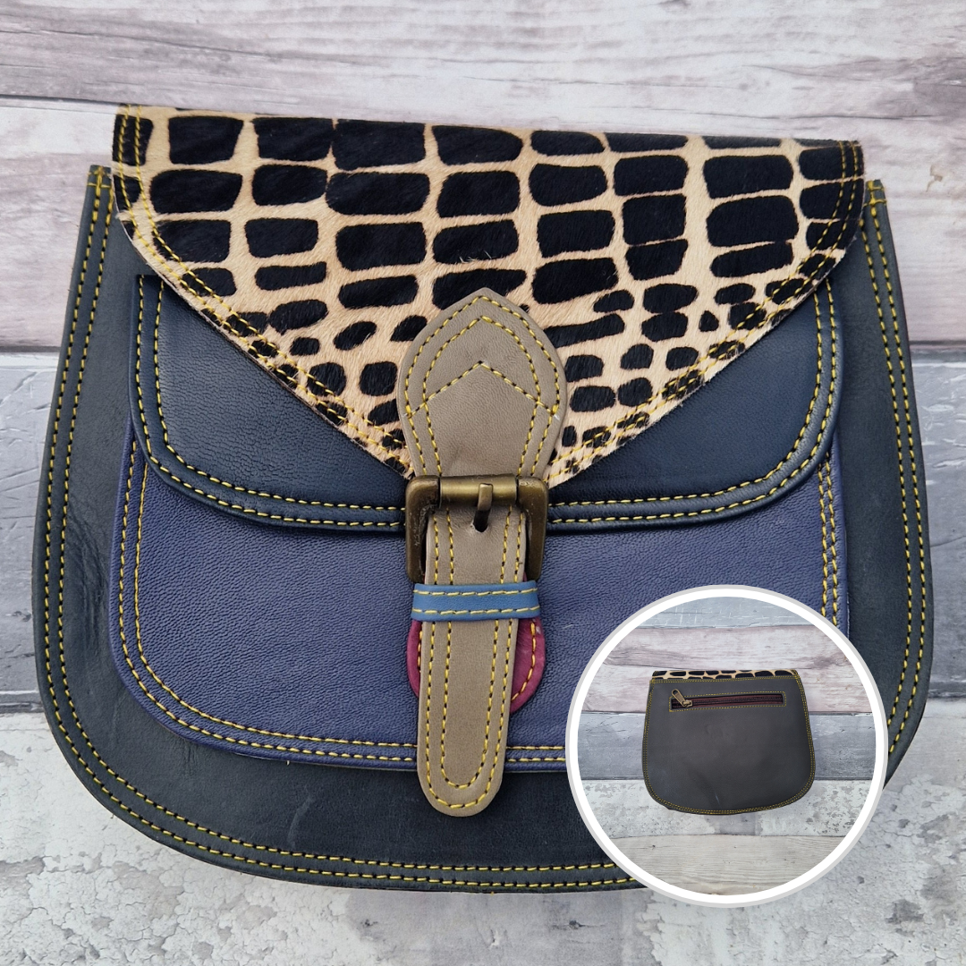 Saddlebag style bag in navy leather with contrasting coloured panels and a section of textured giraffe print.