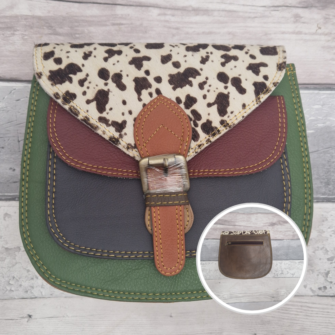 Saddlebag style bag in green coloured leather with contrasting coloured panels and a section of textured cow print