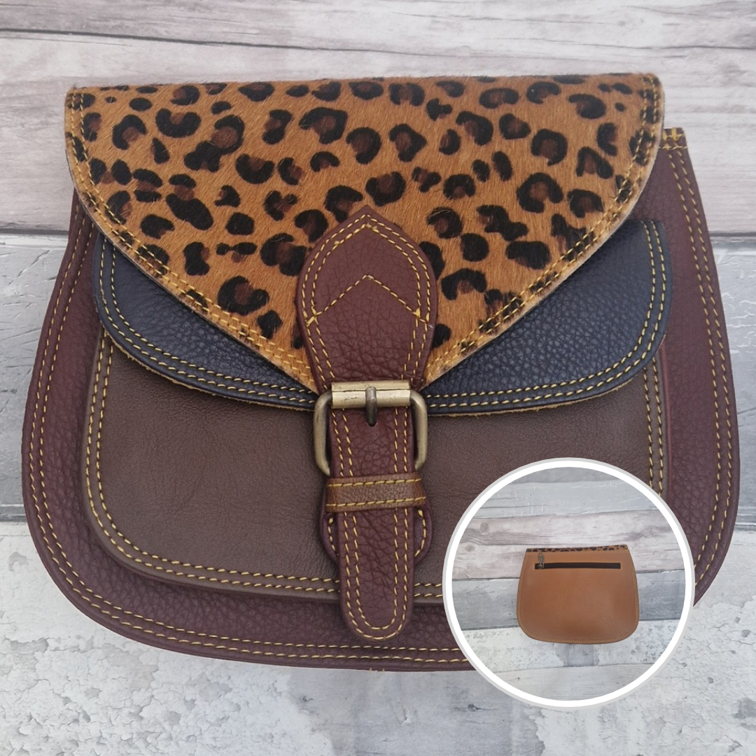Saddlebag style bag in burgundy coloured leather with contrasting coloured panels and a section of textured leopard Print