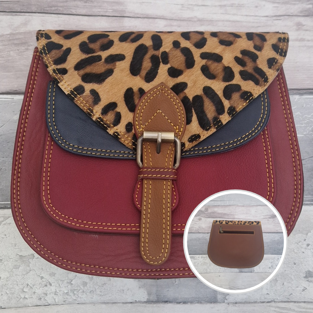 Saddlebag style bag in red coloured leather with contrasting coloured panels and a section of textured leopard Print